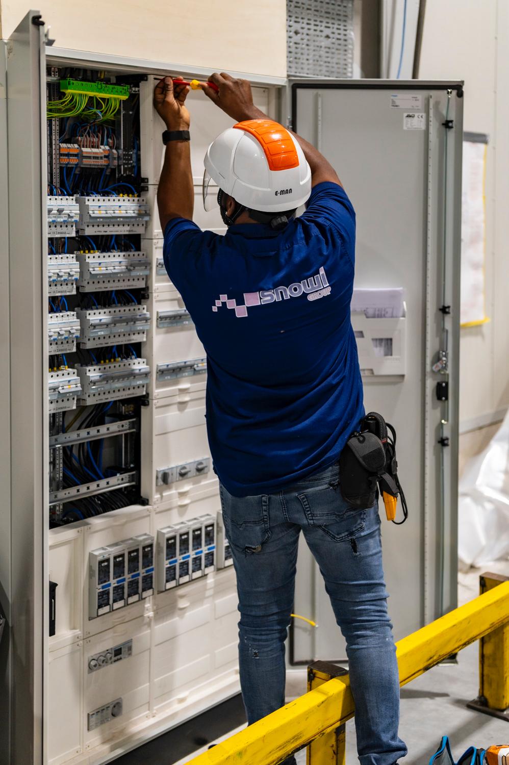 SNOWI-monteur werkt aan een elektrische verdeler